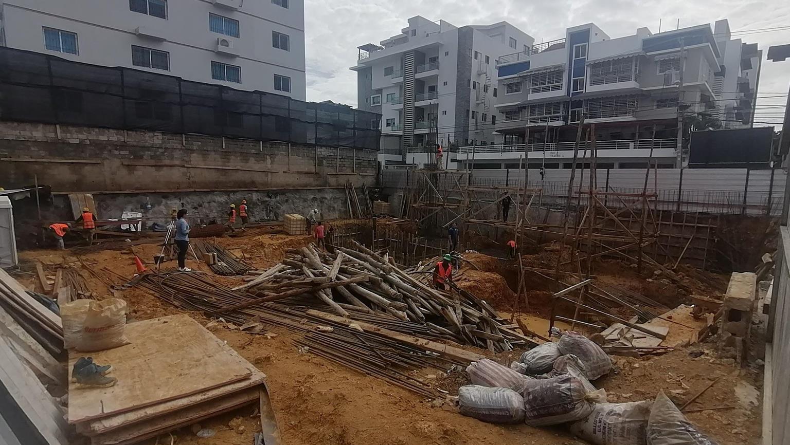 Equipo de agrimensura y construcción trabajando en la excavación de cimientos de un edificio