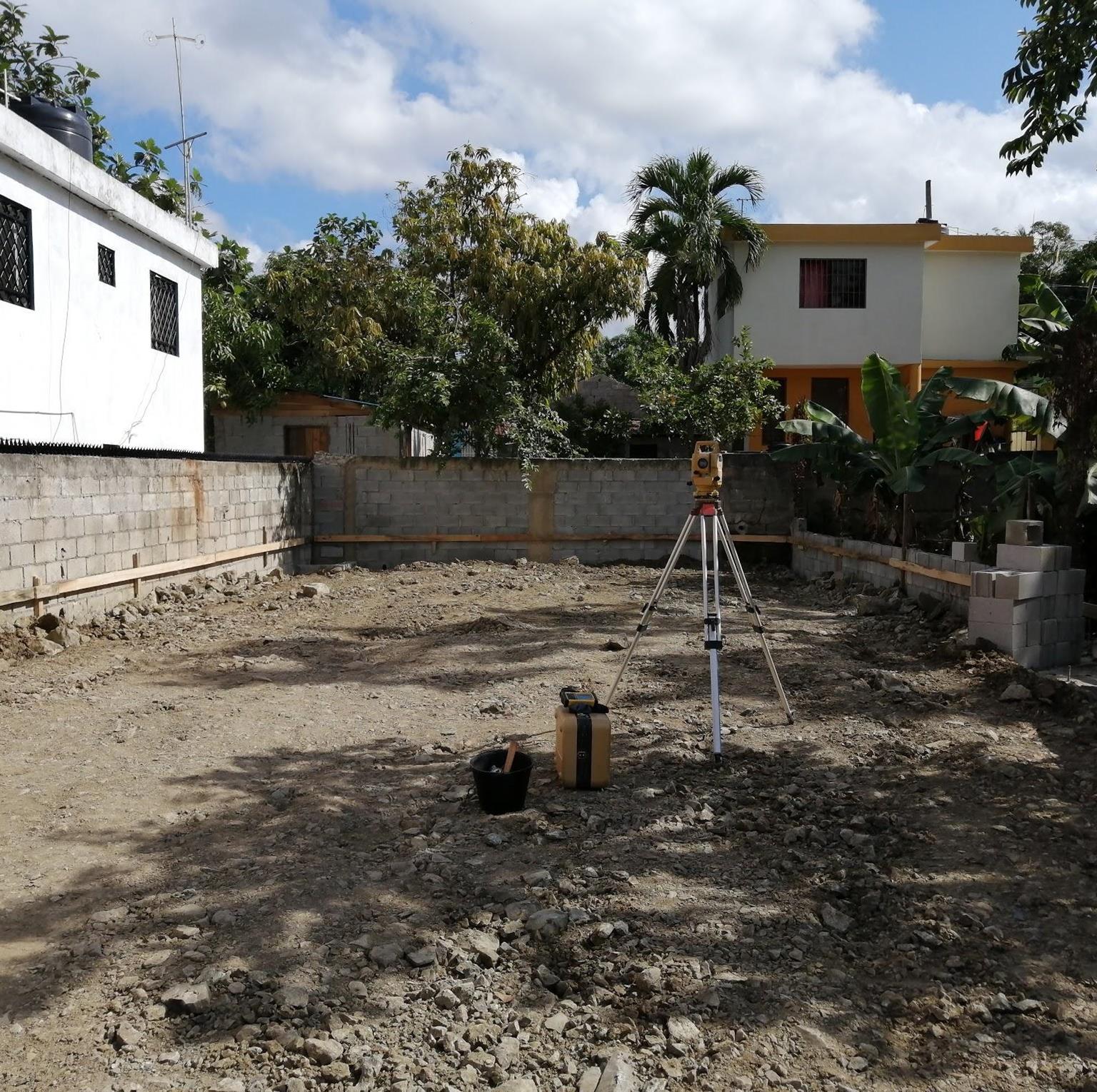 Estación total midiendo los linderos de un solar residencial en un servicio de agrimensura