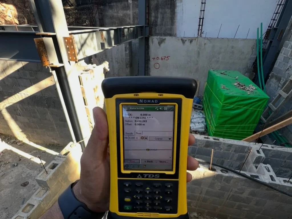 Colectora de datos en la mano durante el control de una obra con armaduras